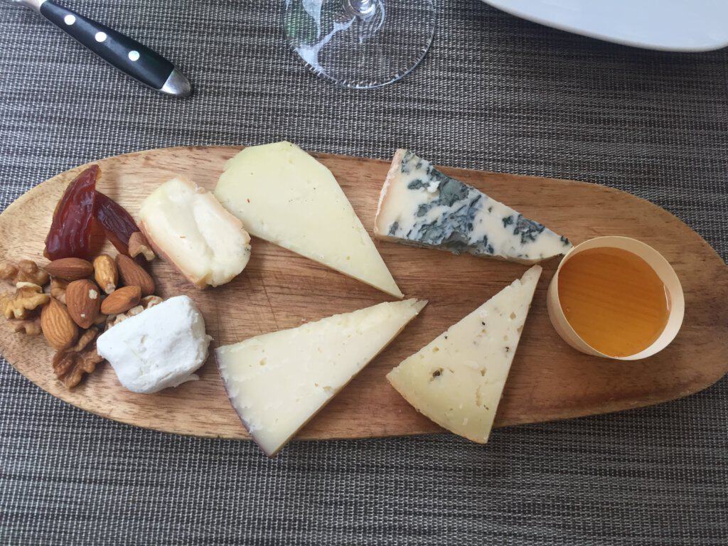 Six different types of cheese on a wooden plate