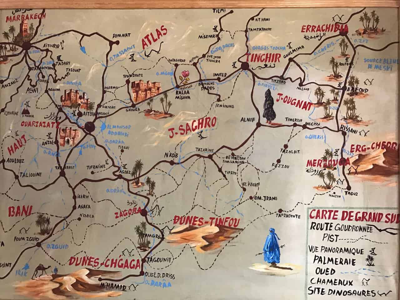 Artistic map of southern Morocco highlighting desert regions, towns, dunes, and travel routes through the Atlas Mountains and Sahara Desert