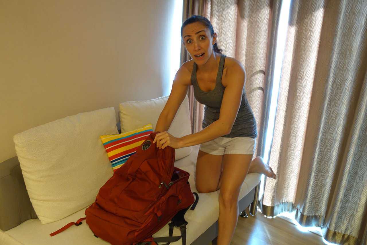 woman looking inside of her backpack using her weekend getaway packing list to make it all fit 