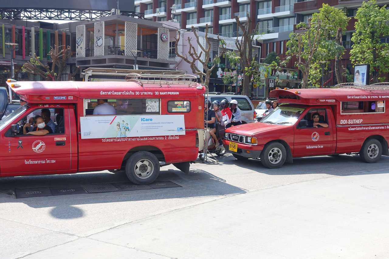 Two red buses on their way to the airport at krabi 