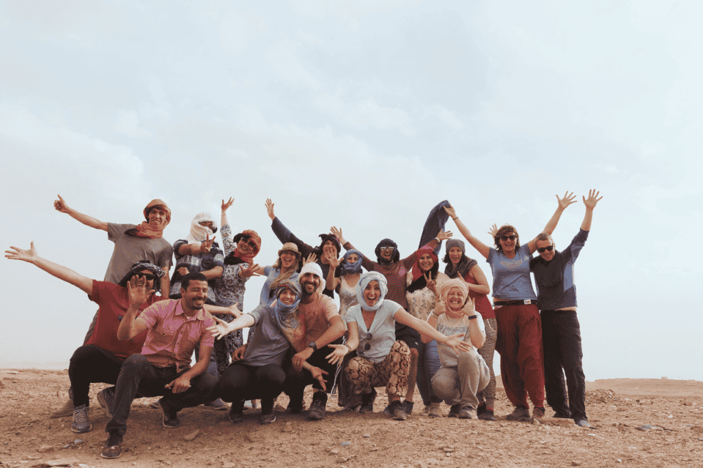 group of travelers wearing head scarfs in the Sahara desert 