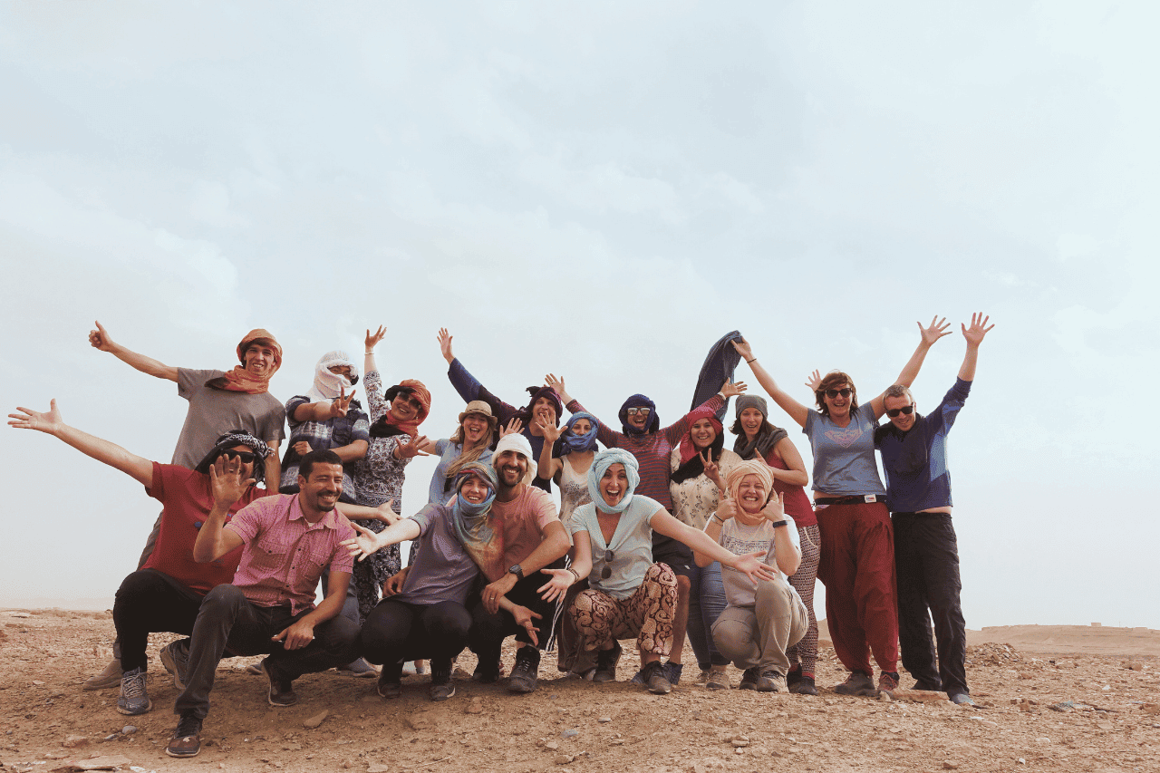 group of travelers wearing head scarfs in the Sahara desert booked through travel websites 