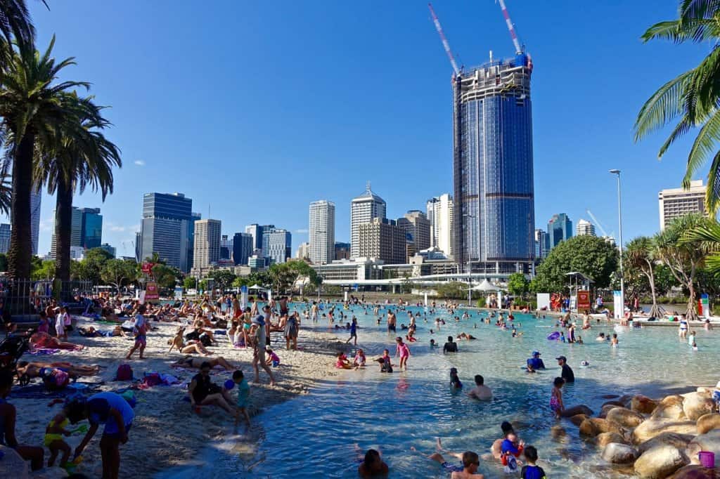 A beach scene and a tall building in Brisbane