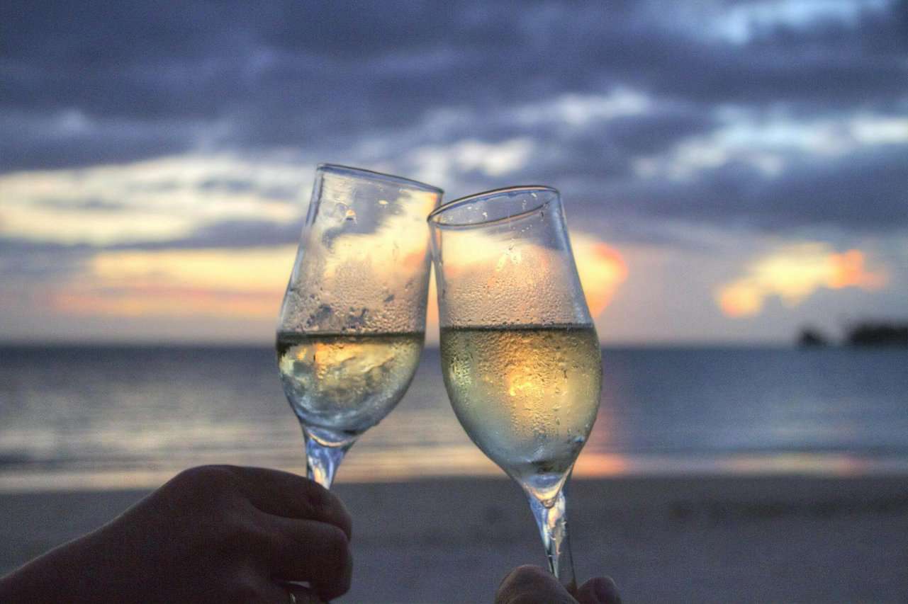 two people toasting flute glasses