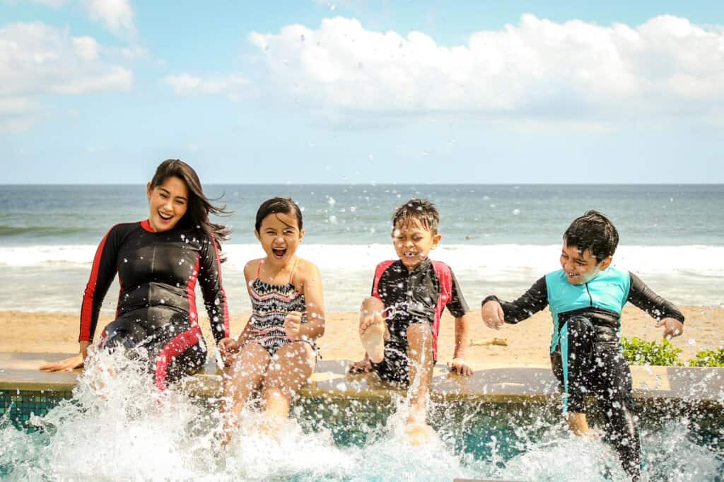 woman and three children playing water as a family friendly activities