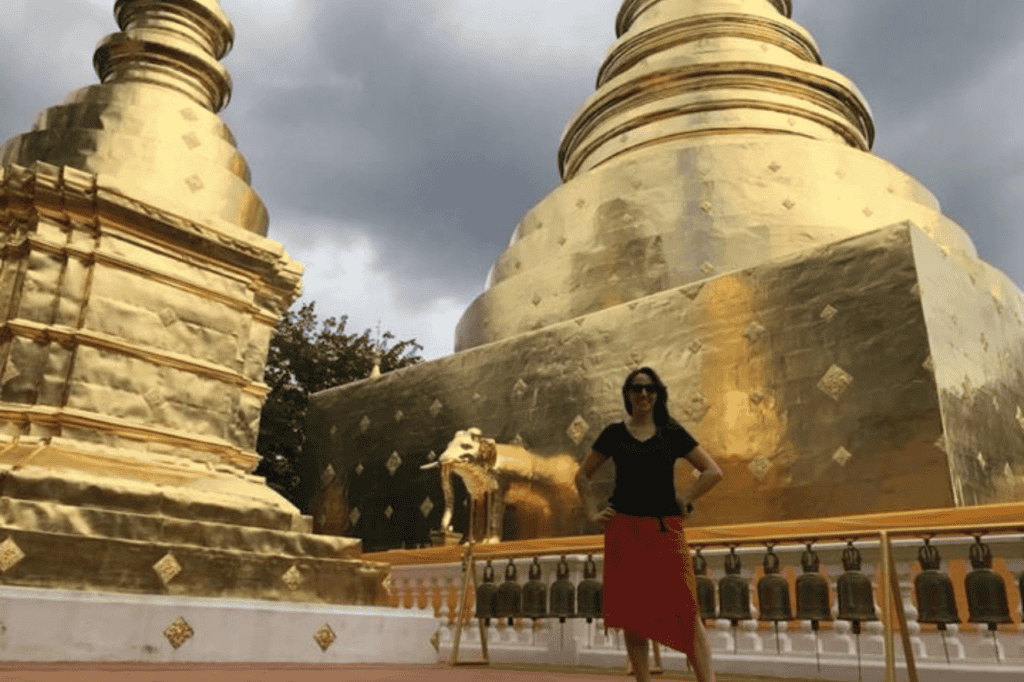 woman standing in front of one of the chiang mai gold temples