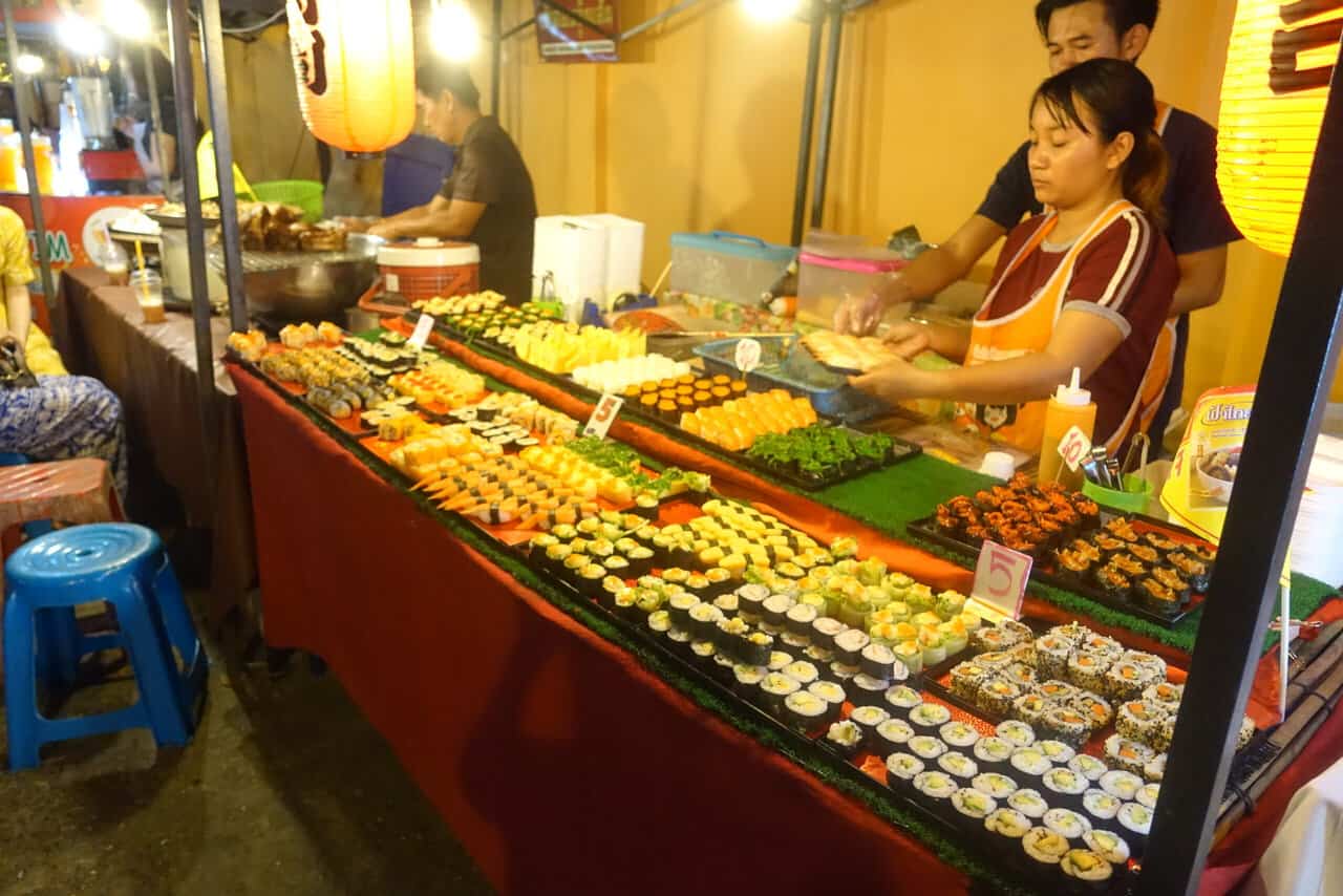 woman working at a sushi stand at the chiang mai market