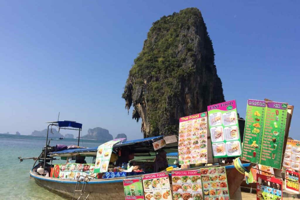 single long tail boat with colorful menu pricing on the side 