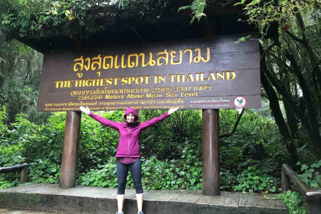 woman standing in front of a wooden sign