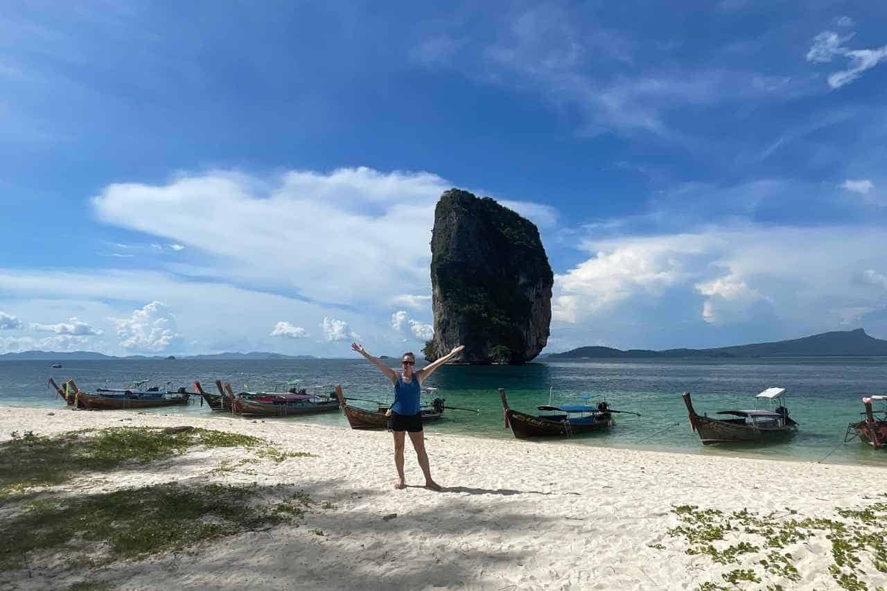 woman with her arms up on white sand beaches near ao nang