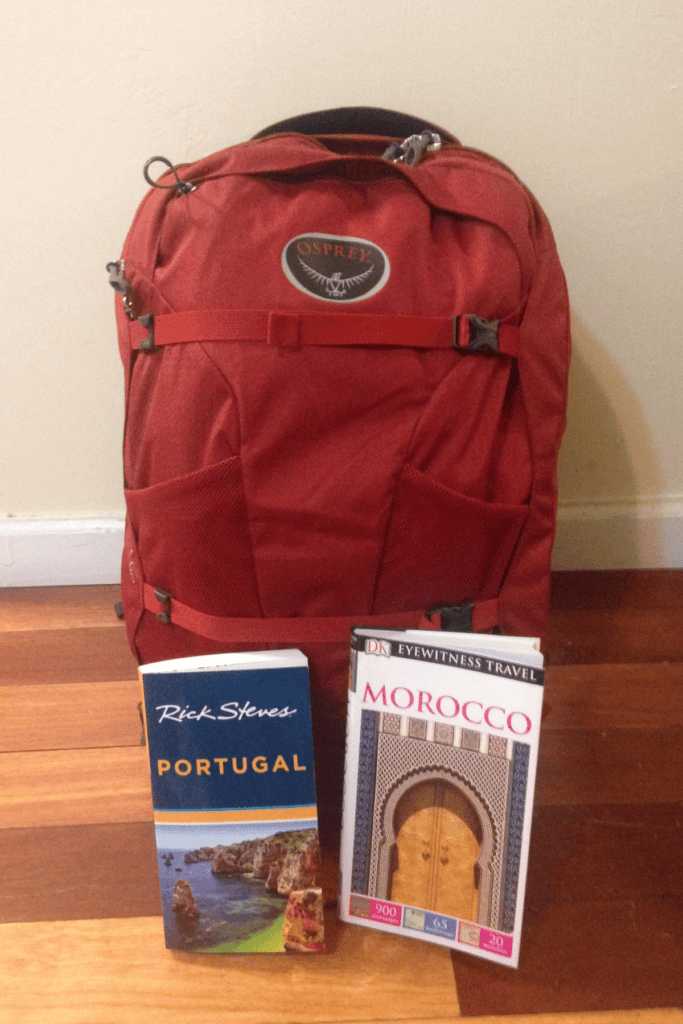 red osprey backpack and two books for portugal and morocco