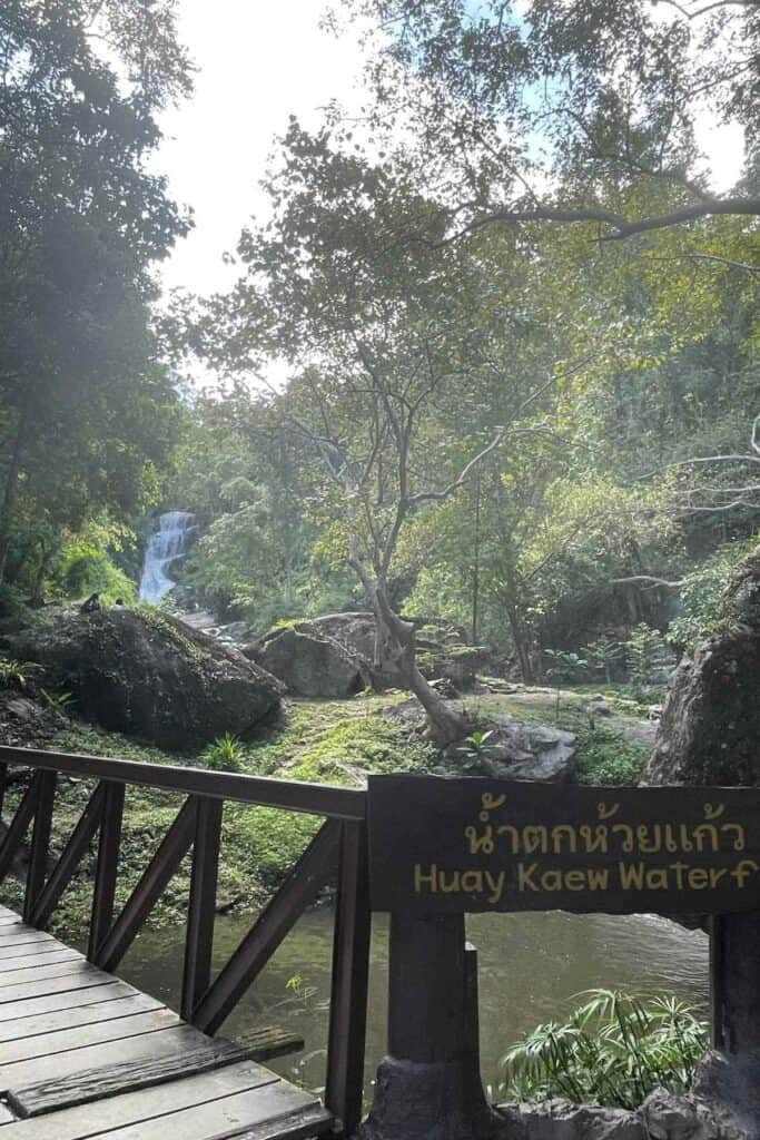 wooden sign and entrance to huay kaew waterfall