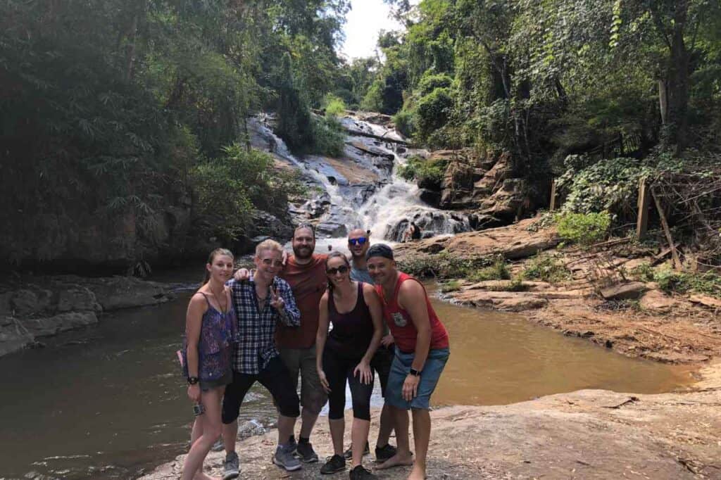 group of people in front of the mae sa waterfall in chiang mai