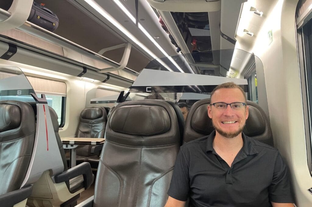 man siting inside of a train car in italy 