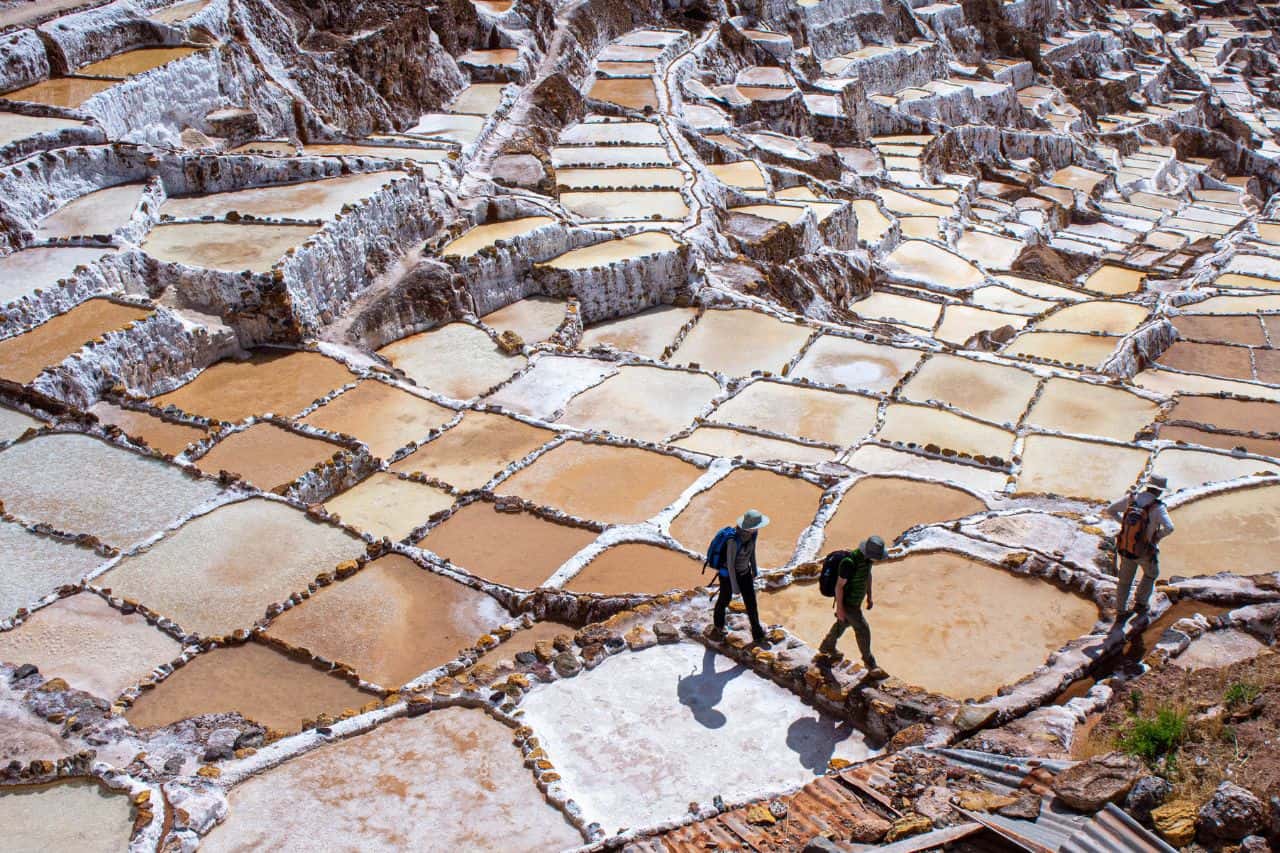 hikers visiting the white and brown salt mines in peru