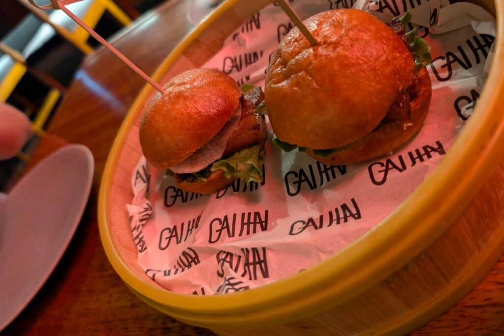 two pork belly sliders in a wooden basket