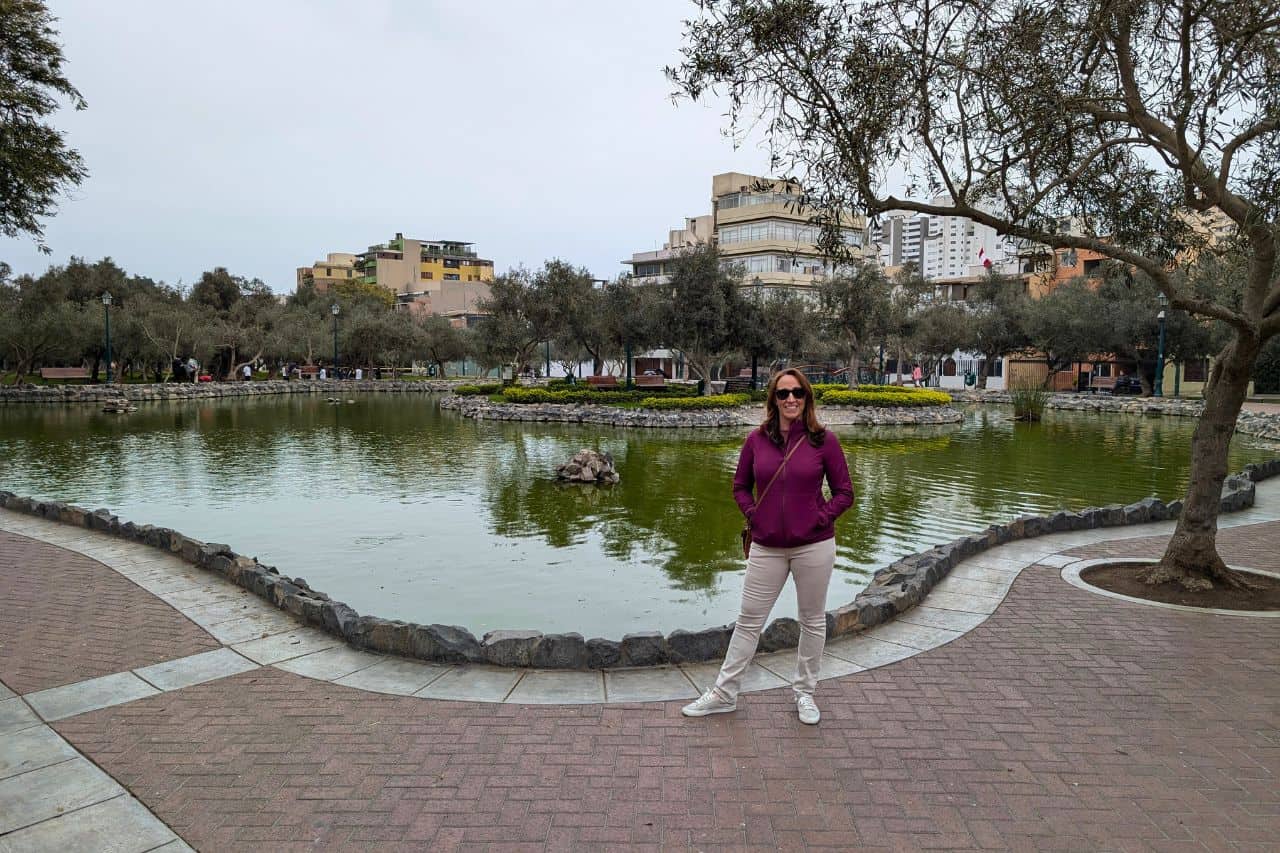 A woman standing in front of a lake in apark– things to do in Lima.