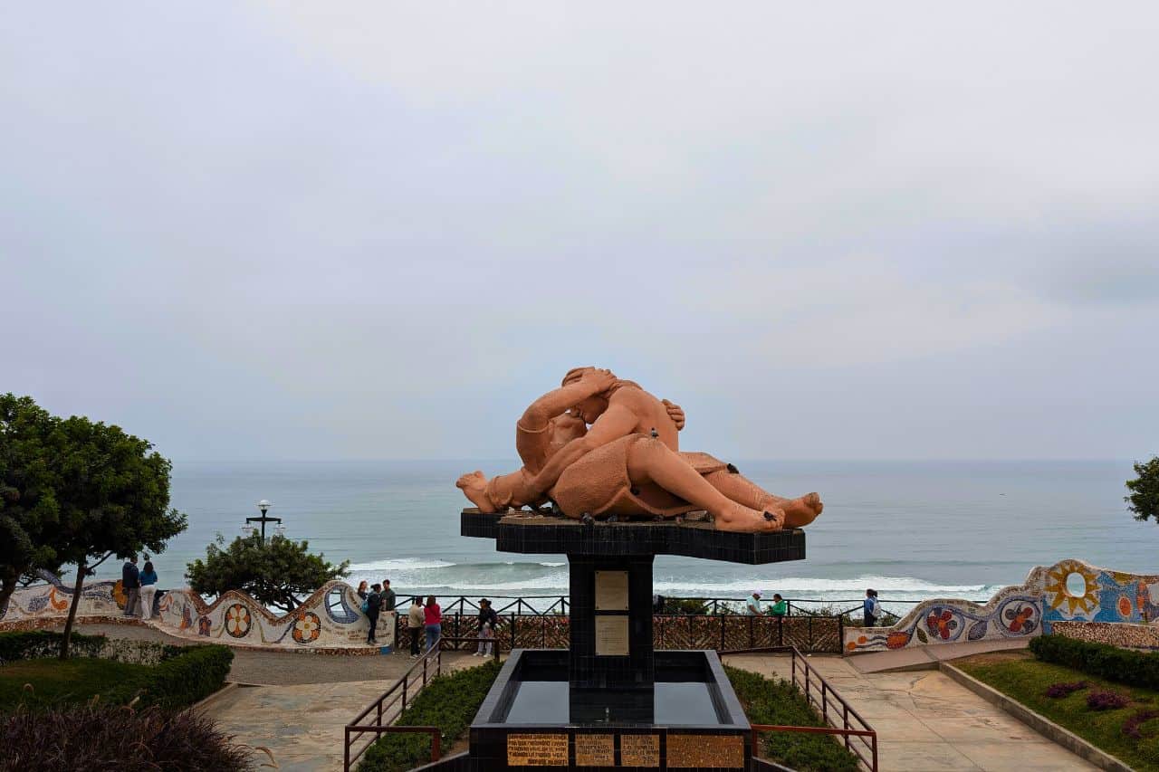 A sculpture of two people kissing on the waterfront - things to do in Lima