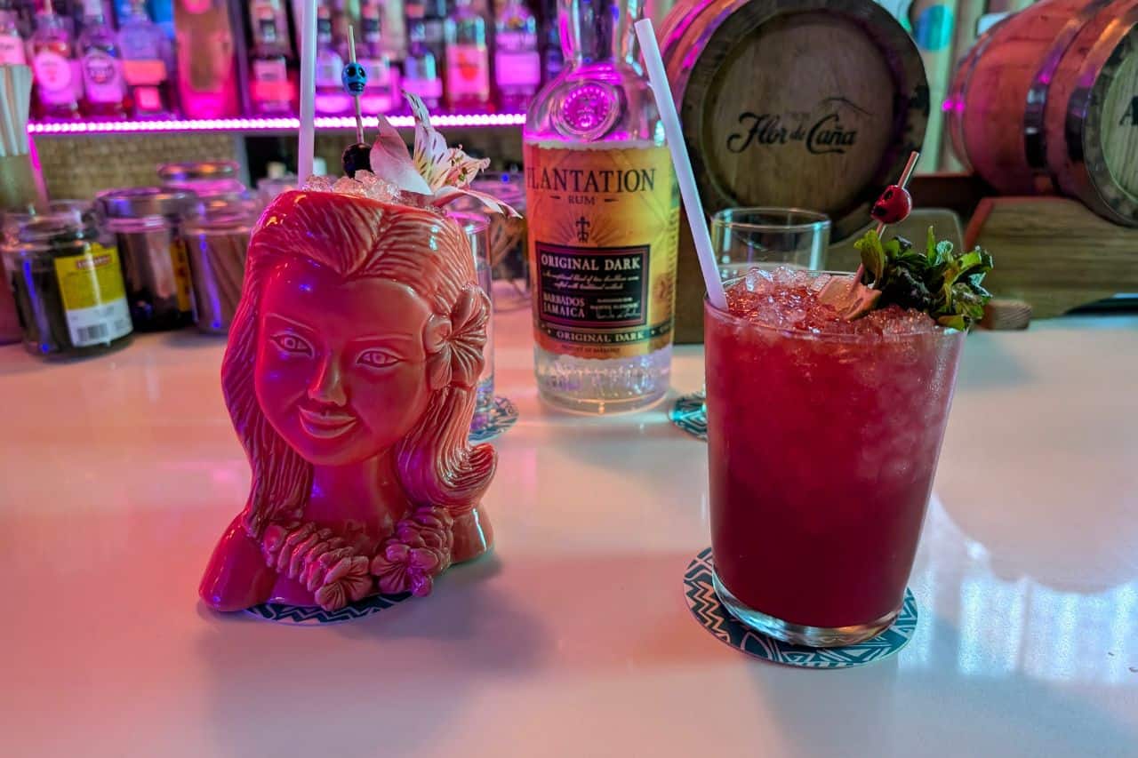 Two colorful Tiki cocktails on a bar