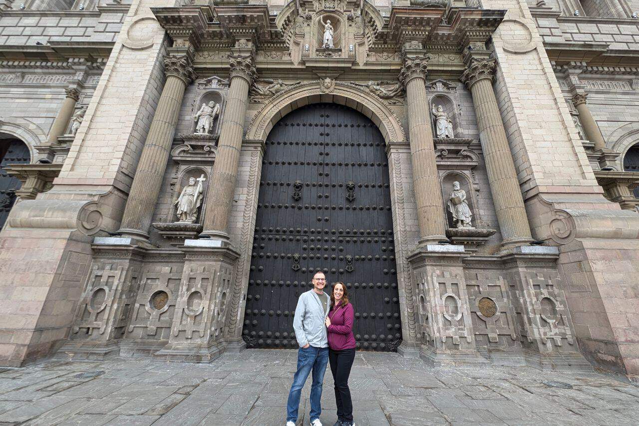 A couple standing in front of a cathedral in downtown Lima