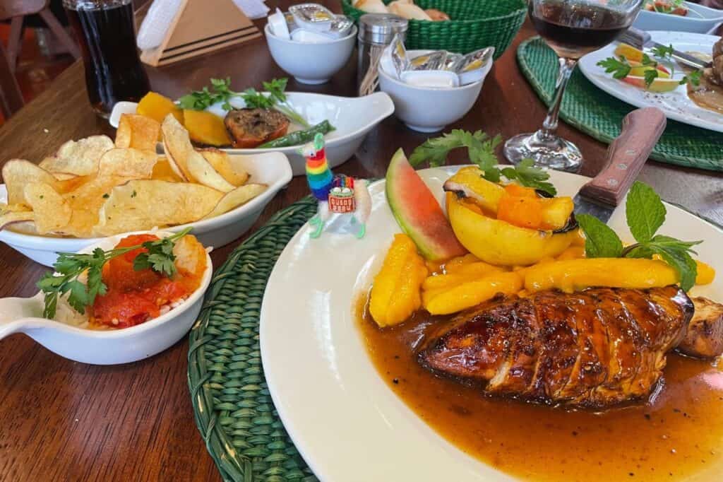 Large colorful plates of Peruvian chicken and fruit