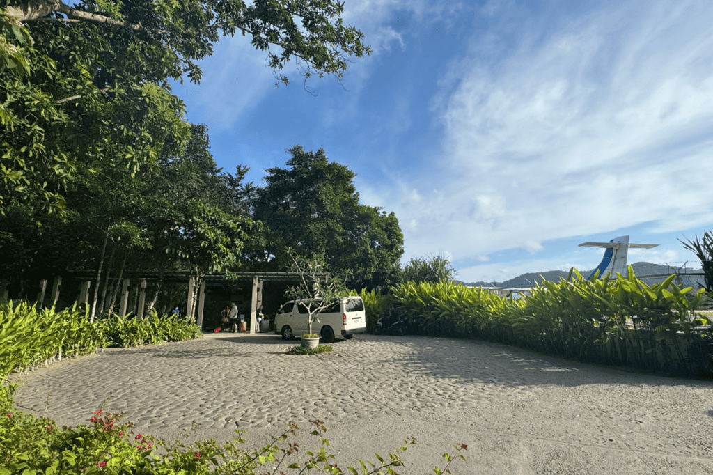 The exterior of the airport in El Nido, the tail of a plane and lush greenery