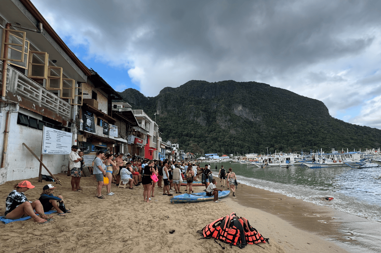 People standing in line on the beach waiting to board the tours in El Nido