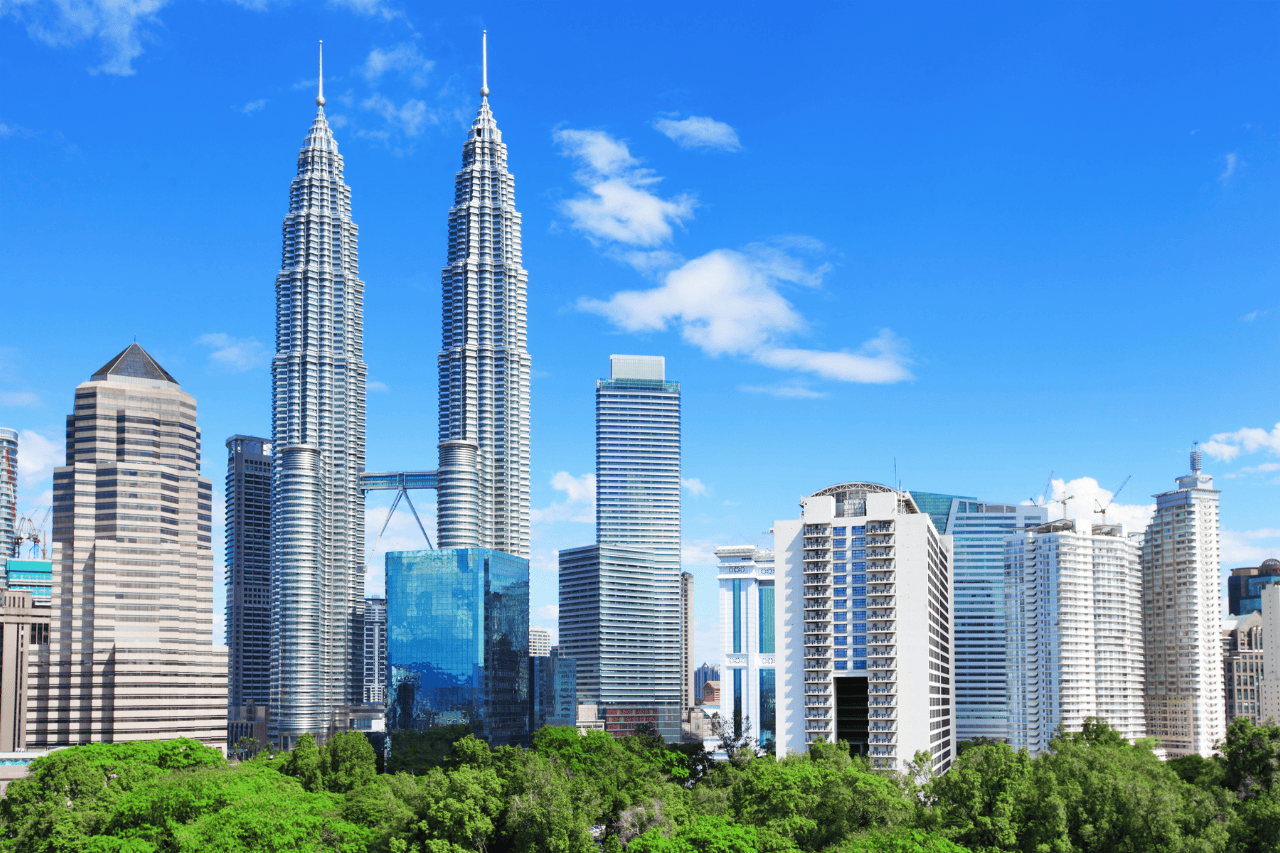 A scenic view of downtown Kuala Lumpur featuring the Petronas Towers and city skyline