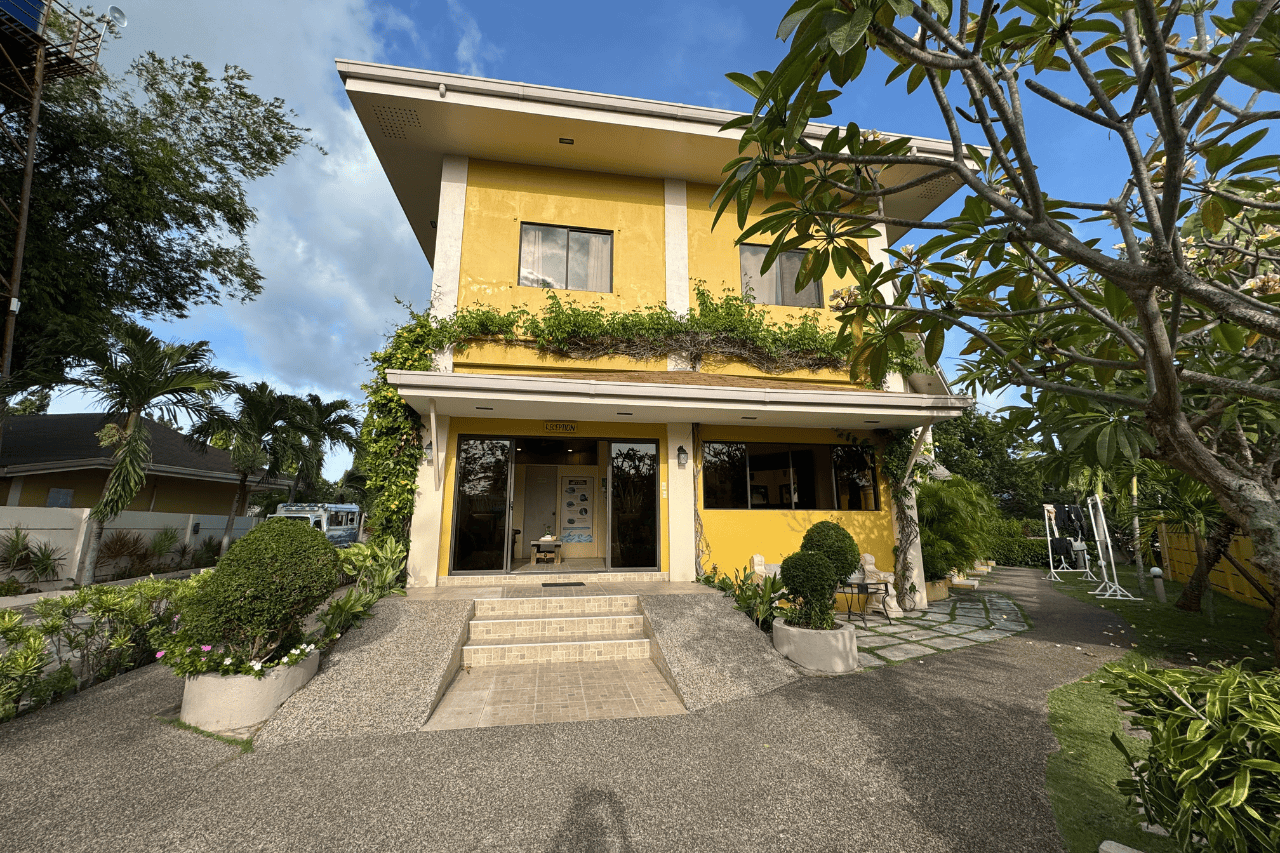 Yellow facade of Turtle Bay Dive Resort, a charming beachfront hotel in Moalboal, Cebu.