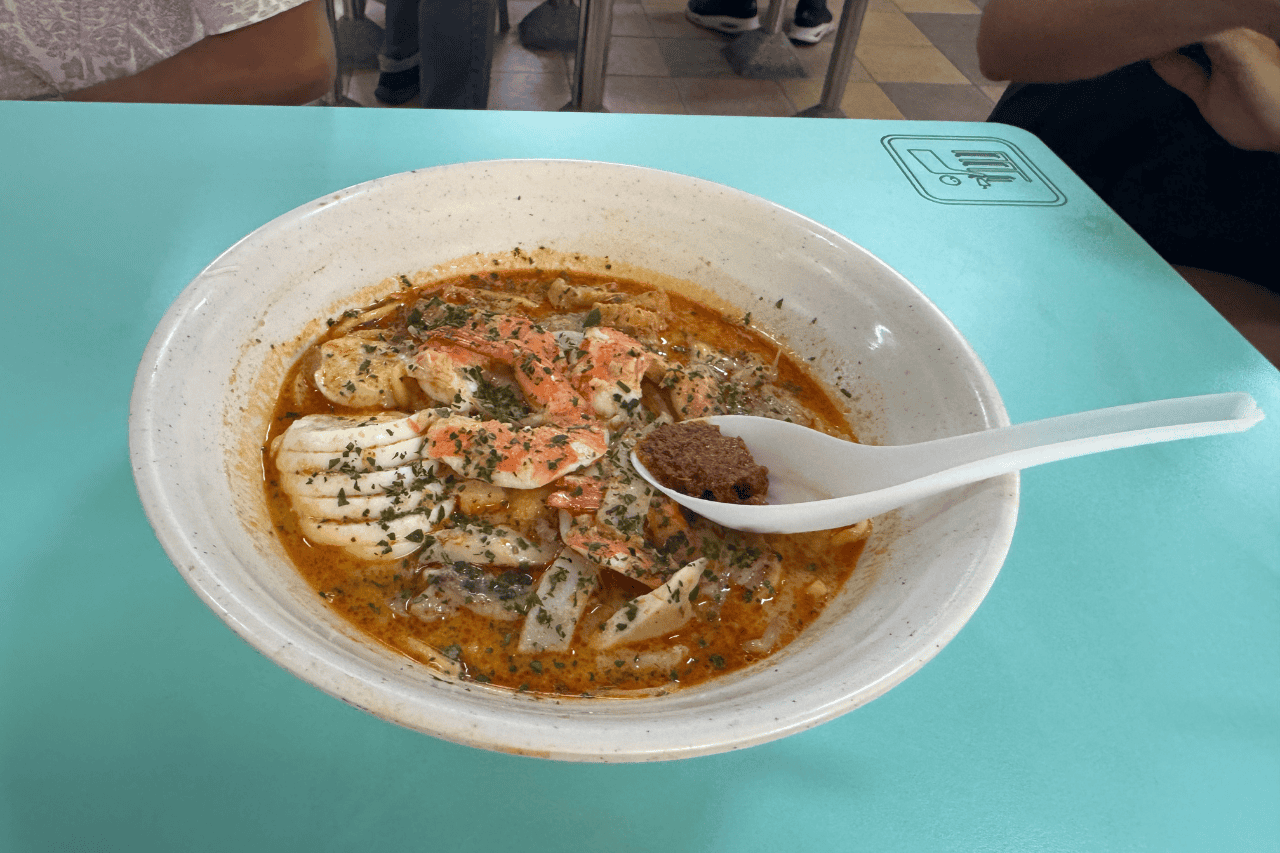 Bowl of noodles and pork in one of the Hawker stalls in Singapore