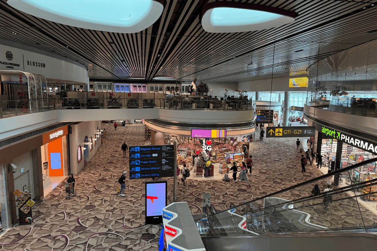 Passengers walking through Changi Airport – travel insurance for Singapore provides peace of mind for unexpected delays or lost luggage.