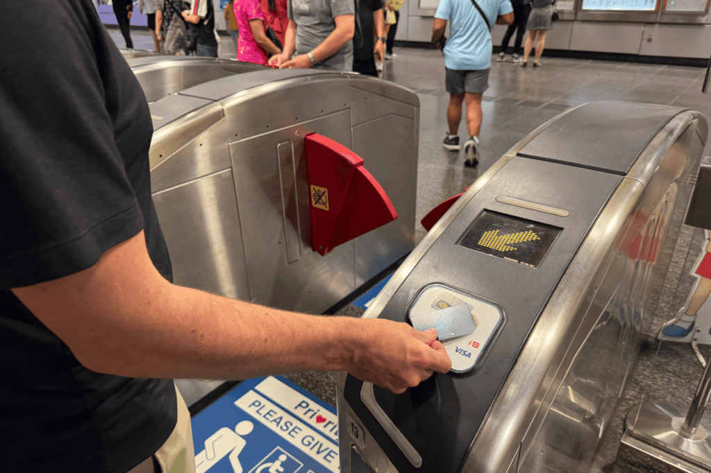 Man using a credit card to pay for the MRT turnstile instead of using a ticket