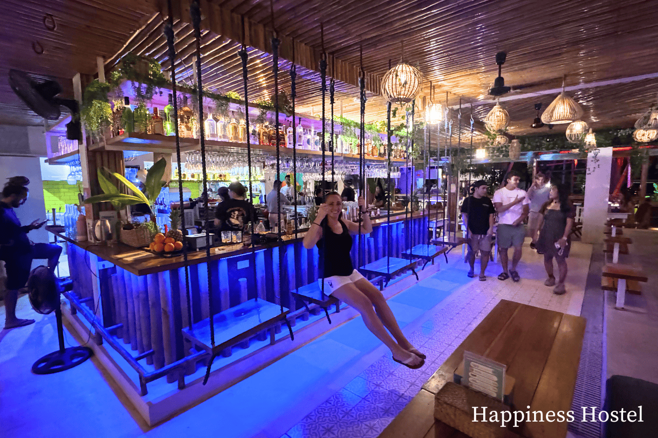 Woman on a swing seat at a hostel bar