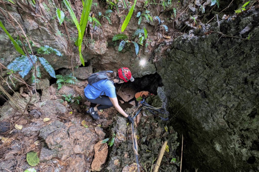 Woman climbing inside the Marvelos Somoyot Cave with headlamp and guide