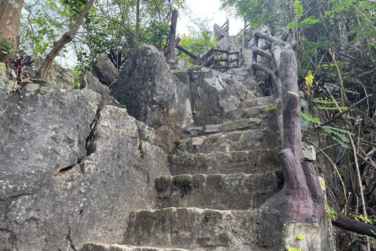 Steep stone steps with rustic wooden railings climbing through rocky terrain at Marble Mountains Vietnam