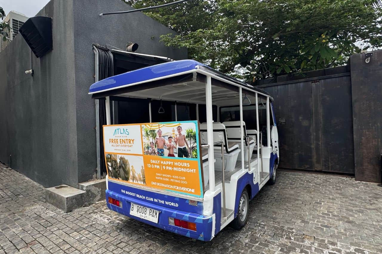 Blue and white shuttle vehicle offering free rides to Atlas Beach Club visitors in Bali.