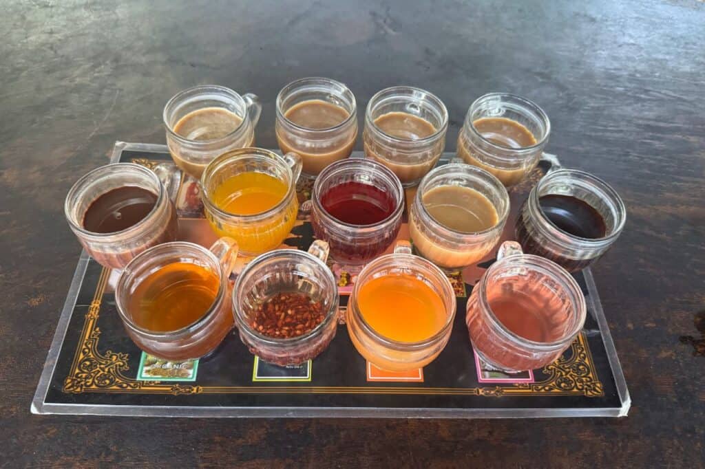 A tray of various coffee and tea samples in clear glass cups during a tasting experience in Bali.