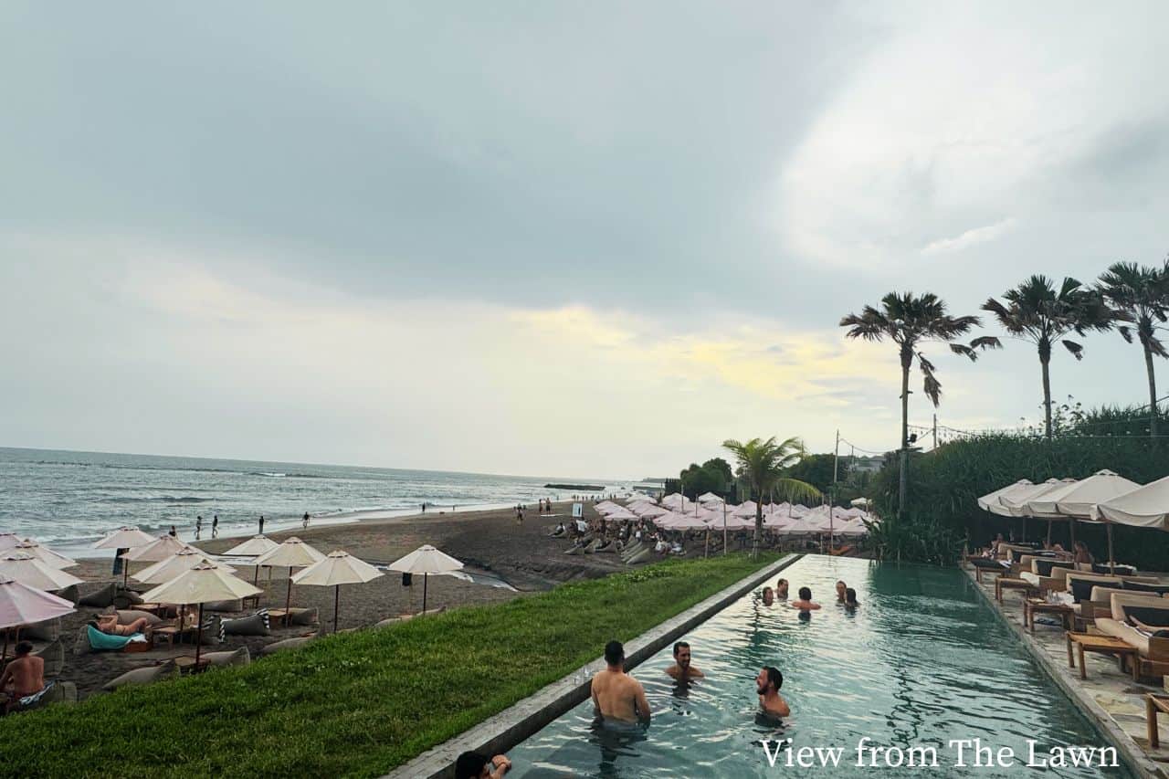 View of beach in Canggu Bali with swimming pool and people relaxing near the ocean