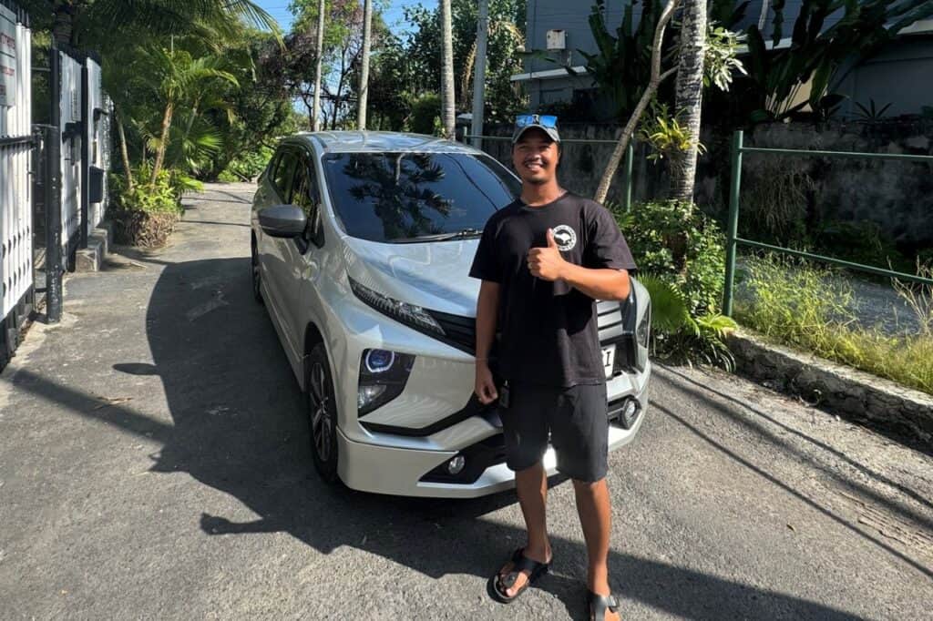 Private Bali driver standing in front of a white vehicle giving a thumbs up 