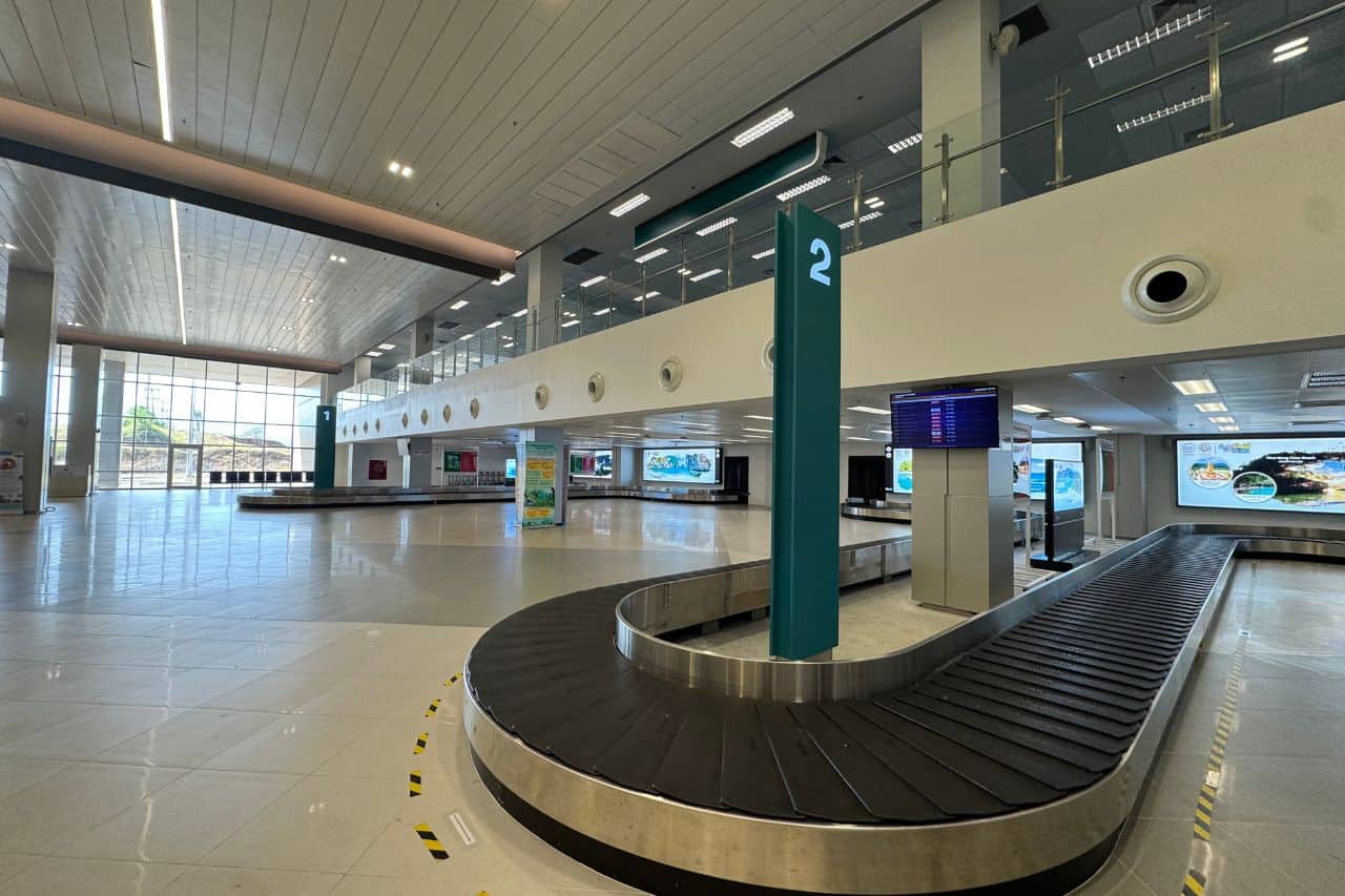 Spacious and modern baggage claim area at the airport in Krabi, Thailand, with carousel number signs and natural lighting
