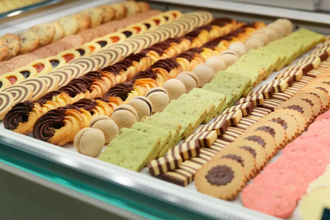 Italian Cookie Assortment - Little Italy NYC Bakery Delights Display case filled with assorted Italian cookies in various shapes and colors, highlighting the dessert offerings in Little Italy NYC