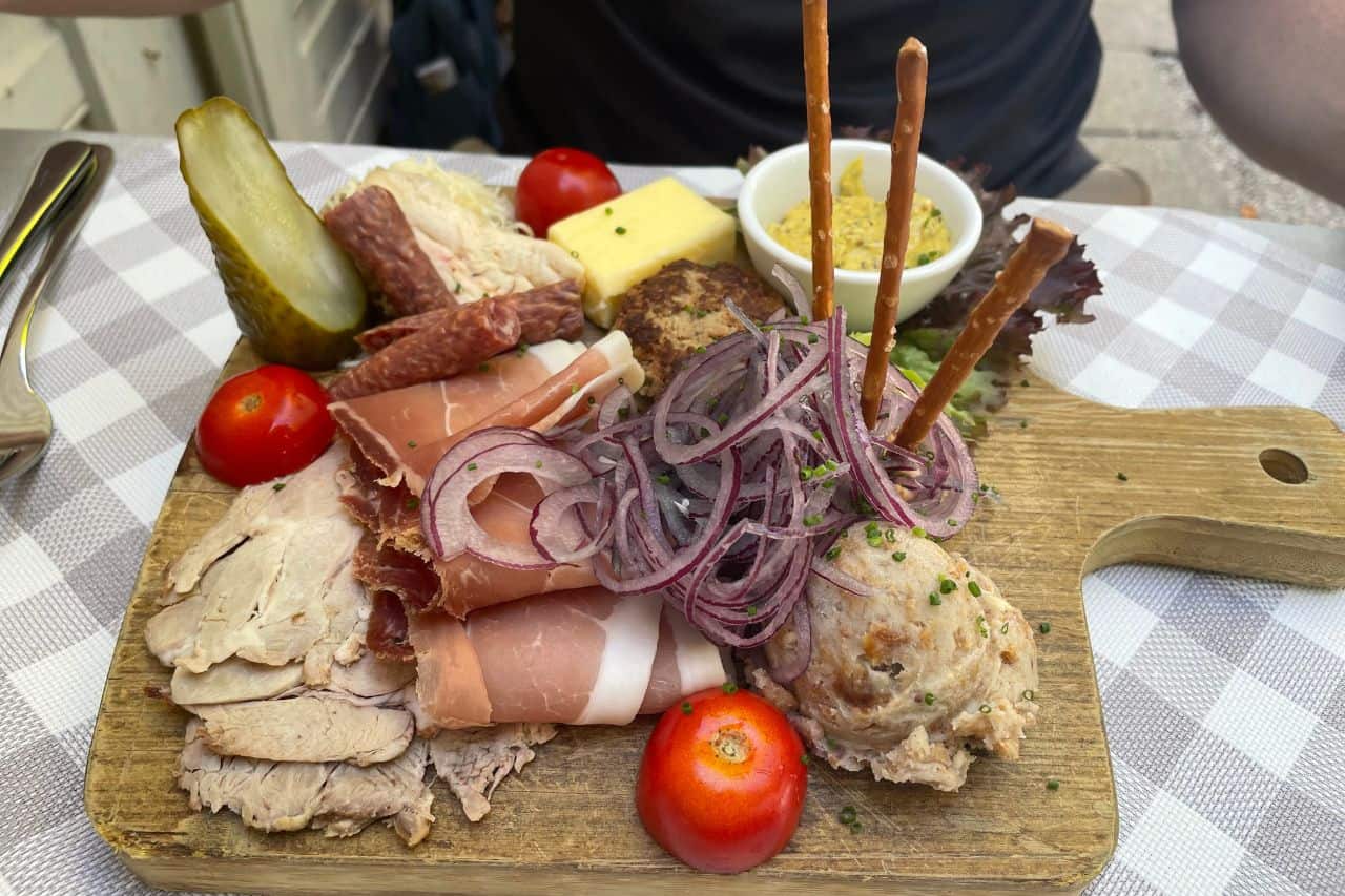 Traditional German sausage and cheese platter served on a wooden board in Munich