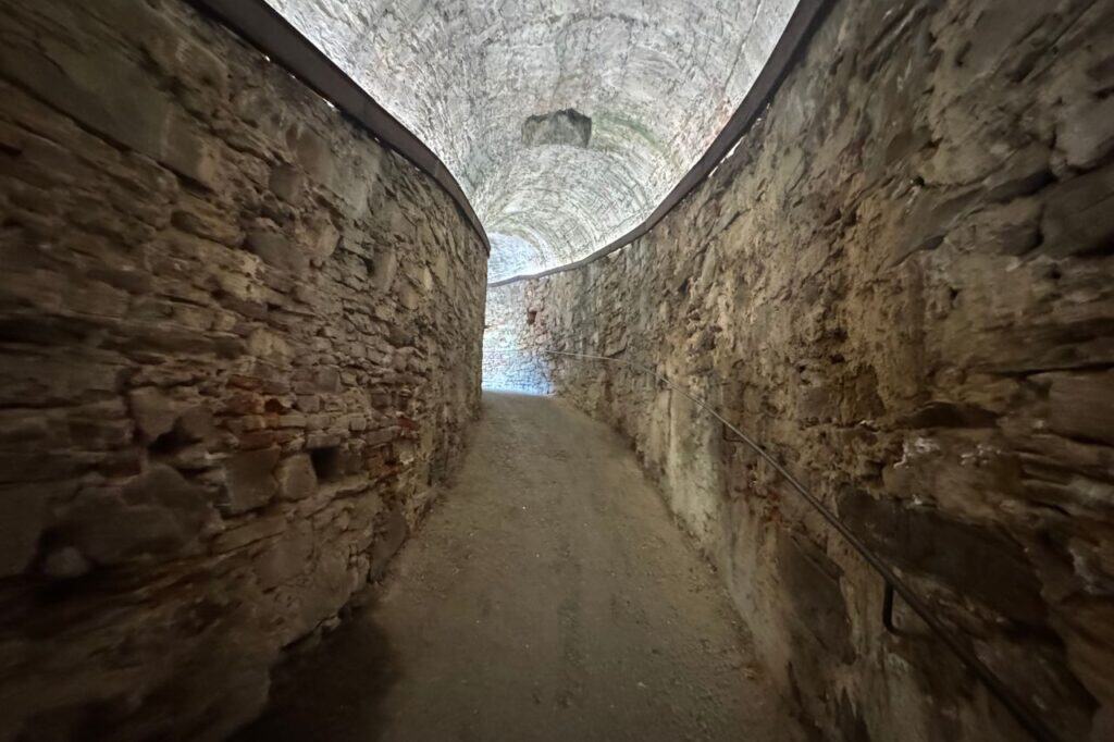 Narrow stone hallway leading into the historic walled city of Lucca Italy