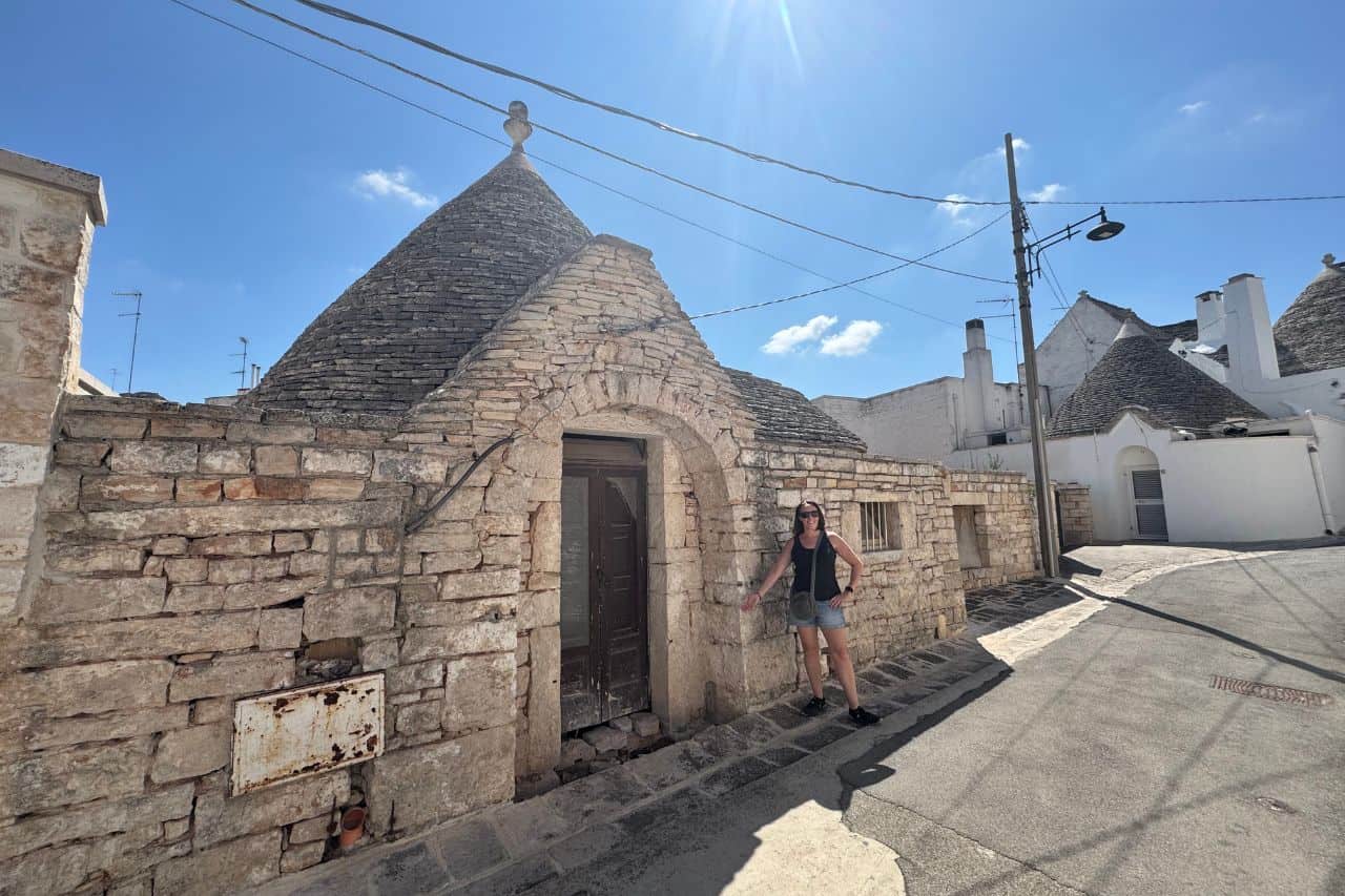 Street View of Trulli Houses in Alberobello Row of traditional white Trulli houses with cone-shaped roofs lining a cobblestone street in Alberobello, one of the easy day trips from Bari