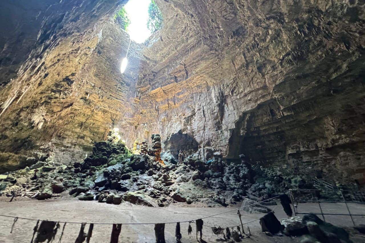 Interior of Grotte di Castellana with Skylight Inside view of Grotte di Castellana showing limestone formations illuminated by natural skylight