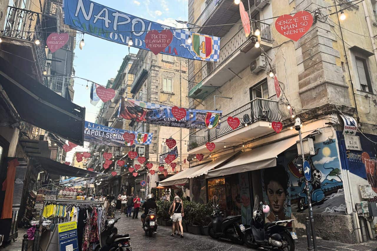 Naples street decorated with blue and white banners Narrow Naples street decorated with blue and white “Napoli Sempre” banners hanging overhead that you will see during your 1 day in Naples Italy