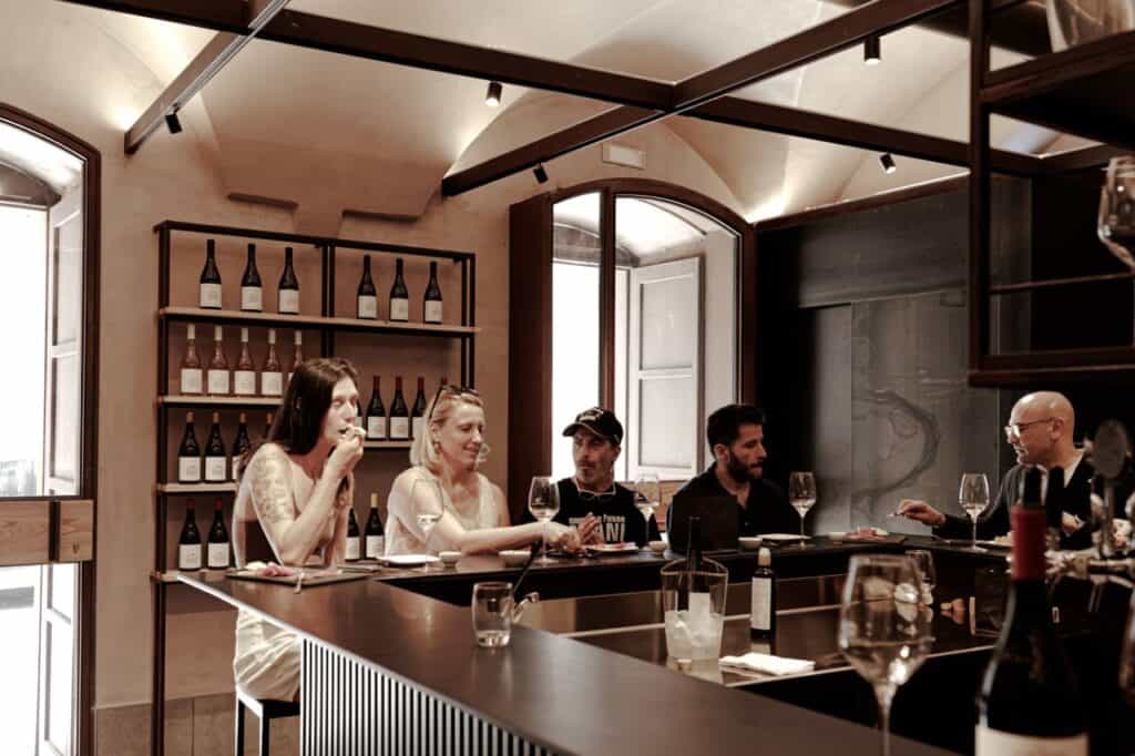 Visitors enjoying a guided wine tasting at Tenute dei Ciclopi, a wine bar and tasting room in Catania, Sicily.